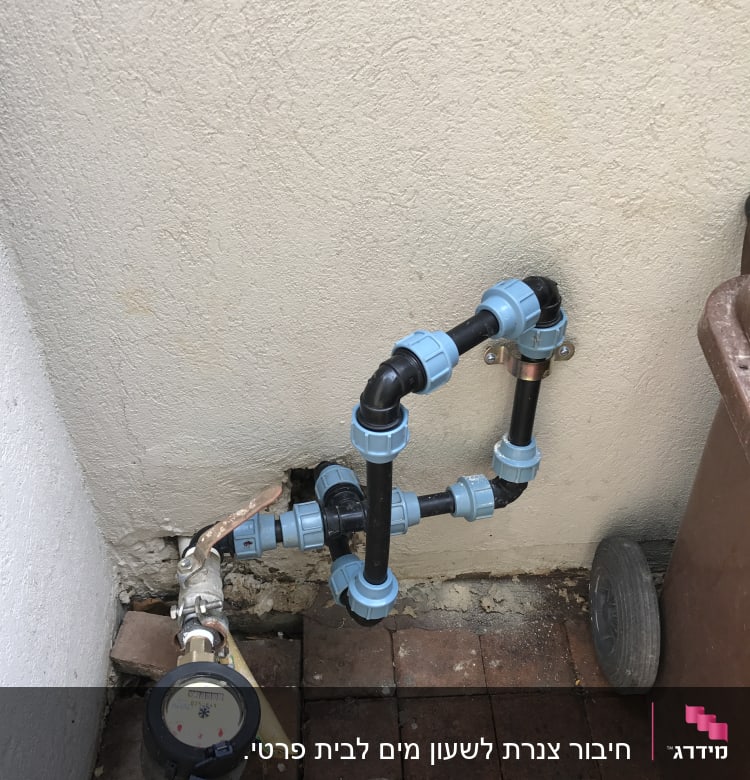 צנרת מים עם מחברים כחולים ומד מים